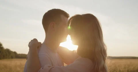 Young attractive couple having a date at sunset in a golden wheat field Stock Footage 237810969