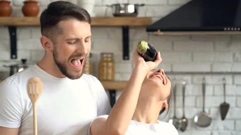 Young attractive couple having fun together at the kitchen. Singing, having fun. Stock Footage 105122200