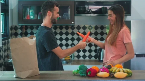 Young Attractive Couple Having fun with Vegetables in Kitchen. Stock Footage 114667111