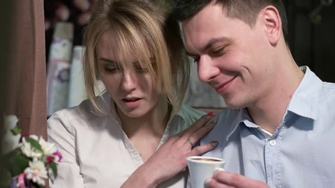 Young attractive couple looking at a tablet in a cafe Stock Footage 77311954