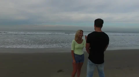 A young, attractive couple talking on the beach at sunrise. Santa Monica, Stock Footage 68050937