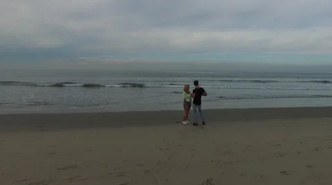A young, attractive couple talking on the beach at sunrise. Santa Monica, Stock Footage 68051013