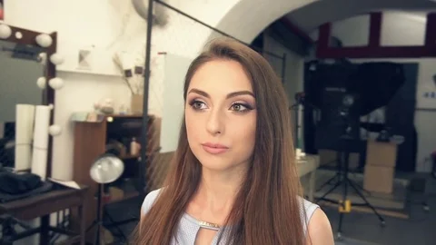 Young attractive female checking her make up in dressing room mirror Stock Footage