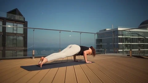 Young attractive female doing yoga on the roof at sea slow motion Stock Footage