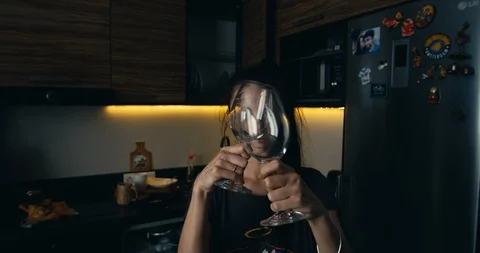 Young attractive female having fun with wine glasses while doing dishes. POV Stock Footage 117980448