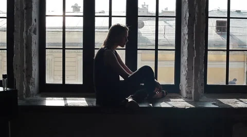 Young attractive female model posing sitting on windowsill  Stock Footage 54636649