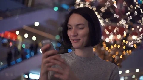 Young attractive girl smiling using smartphone in shopping mall Video stock 83368014