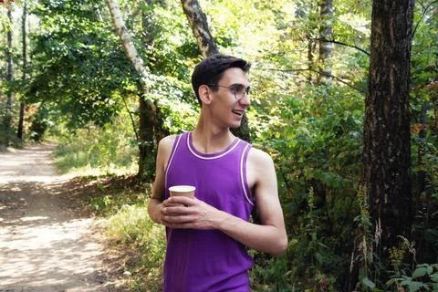Young attractive guy drinks coffee in the autumn park. Foto stock