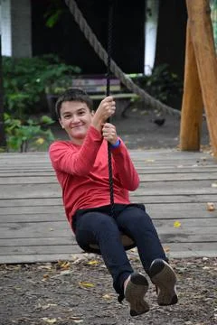 Young attractive guy goes down the zipline and smiles Stock Photos