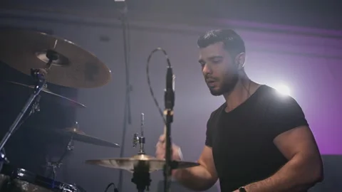 A young attractive guy plays a drum kit. Strikes a cymbal. Performance of a rock Stock Footage 233815726