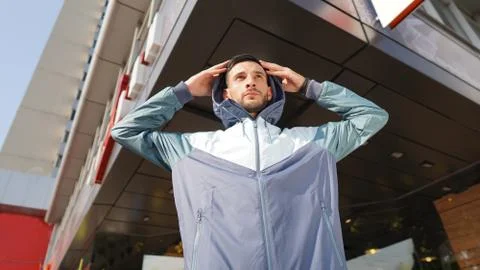 Young attractive guy posing in front of store. Man dressed in training suit . 스톡 사진