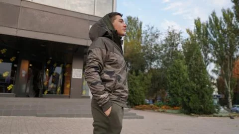 Young attractive guy posing in front of store. Man dressed in training suit . Stock Photos