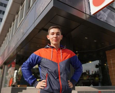 Young attractive guy posing in front of store. Man dressed in training suit . 스톡 사진