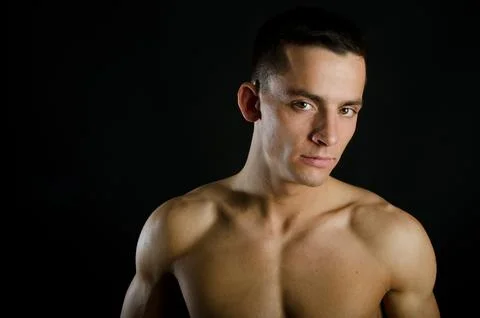 Young attractive guy posing in the studio. Beautiful body. Stock Photos