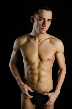 Young attractive guy posing in the studio. Beautiful body. Stock Photos