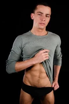Young attractive guy posing in the studio. Beautiful body. Stock Photos