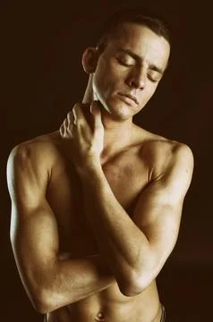 Young attractive guy posing in the studio. Beautiful body. Stock Photos