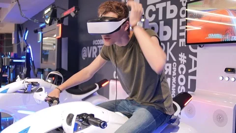 Young attractive handsome guy rides a motorcycle in virtual reality. Holidays Stock Footage 113997381