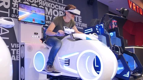 Young attractive handsome guy rides a motorcycle in virtual reality. Holidays Stock Footage 113998260