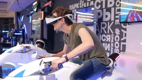 Young attractive handsome guy rides a motorcycle in virtual reality. Holidays Stock Footage 113999067