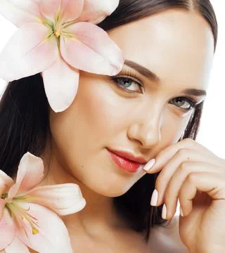 Young attractive lady close up with hands on face isolated flower lily brunette Stock Photos