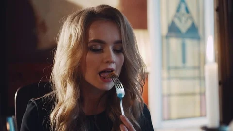 Young attractive lady having a dinner in a restaurant, tasting a dish. Stock Footage 74624833