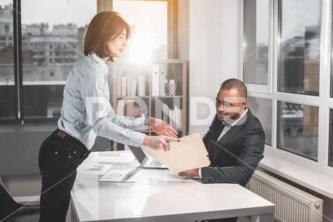 Young attractive lady indicating respectable man on documents Stock Photos