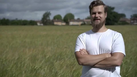 A young attractive male on the rye field background smiles and nods Stock-Footage 134781353