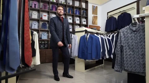 Young attractive man with a beard, dressed in a business suit, dancing in a men Stock Footage 63354960