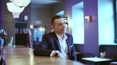 Young attractive man in the dark suit has a relaxation at the evening. Stock Footage 61214816