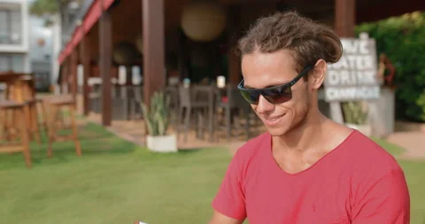 Young, attractive man with dreadlocks in sunglasses uses a tablet computer Stock Footage 107419070