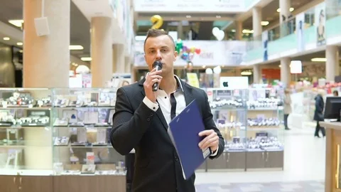 A young attractive man is holding a presentation in a shopping center Stock Footage 74106980