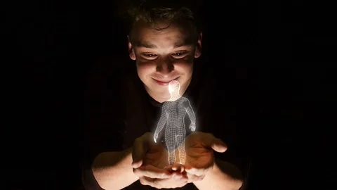 Young attractive man holds a rotating holographic display of a male's body. Stock Footage 110324676