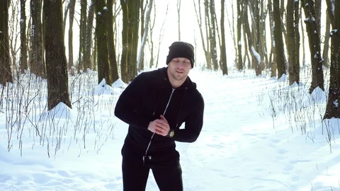 Young attractive man jogger warming up before running outdoors in winter park Stock Footage 87920352