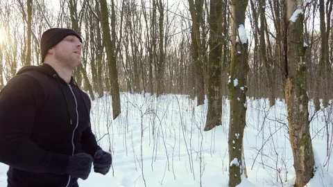 Young attractive man jogger warming up before running outdoors in winter park Stock Footage 87920766