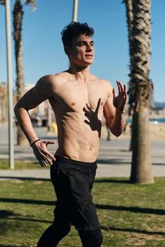 Young attractive man jogging through streets. Fit guy warming up before training Stock Photos