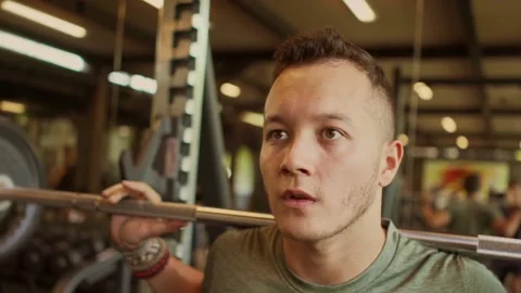 Young attractive man lifting weights training at gym Stock Footage 131803556