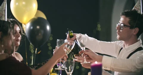 Young attractive man opens a bottle of champagne with a pipe-tongue in his mouth 库存影片 142739716