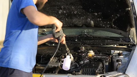 Young attractive man perfusing with water his silver car Stock Footage 90095525