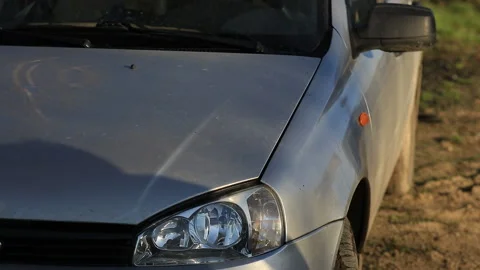Young attractive man perfusing with water his silver car Stock Footage 91339916