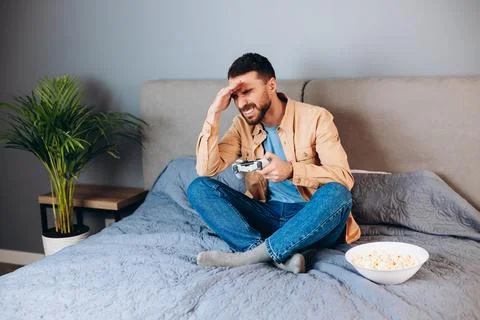 Young attractive man playing console game in front of camera, beating his Stock Photos
