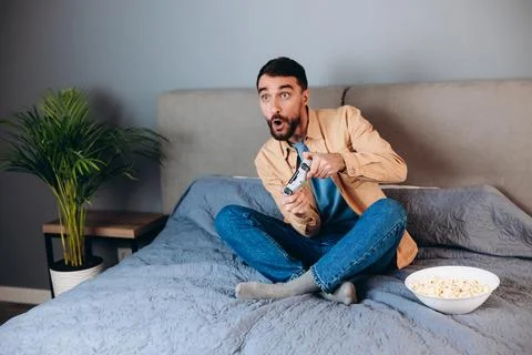 Young attractive man playing console game in front of camera, beating his Stock Photos