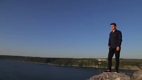 Young attractive man posing for the camera on the lands edge. Stock Footage 93562437