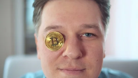 Young attractive man put bitcoin in his eye Stock Footage 106540615