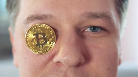 Young attractive man put bitcoin in his eye Stock Footage 106540700