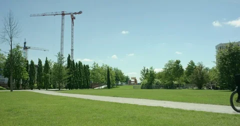 Young attractive man is riding through a green park to his work with his carg Video stock 77553236