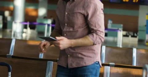 Young attractive man sitting and using his tablet in airport Stock Footage 77522635