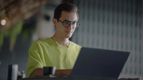 Young attractive man sitting in cafe with laptop and typing text. Slow motion 스톡 동영상 343513848