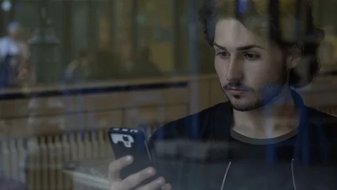 Young attractive man spending time on smartphone social media while waiting f Stock Footage