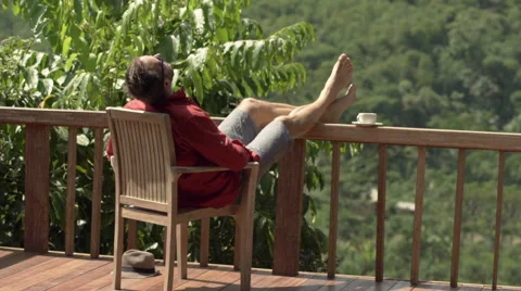 Young, attractive man sunbathing at relaxing while sitting on terrace  HD 스톡 동영상 55679902
